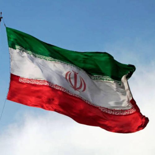 A big flag of Iran waving in the wind in Tehran, Iran.