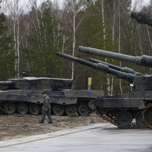 A Polish soldier walks next to the Leopard 2 tanks during a training at a military base and test range in Swietoszow, Poland, Monday, Feb. 13, 2023. The training is part of the European Union's military assistance to Ukraine. (AP Photo/Michal Dyjuk)