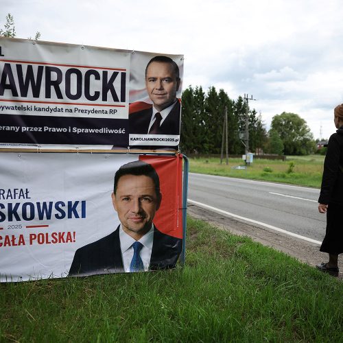 A woman walks near election banners of Karol Nawrocki, a candidate for Polish presidential election supported by Poland's main opposition party Law and Justice (PiS), and Warsaw Mayor Rafal Trzaskowski, Civic Coalition presidential candidate, ahead of the second round of Polish presidential election in Pabianice, May 29, 2025. REUTERS/Kacper Pempel