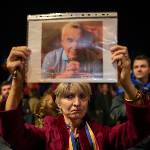A woman holds a portrait of Calin Georgescu during a protest after Romania's Constitutional Court upheld a ban on his candidacy in the presidential election rerun, in Bucharest, Romania, Tuesday, March 11, 2025. (AP Photo/Vadim Ghirda)