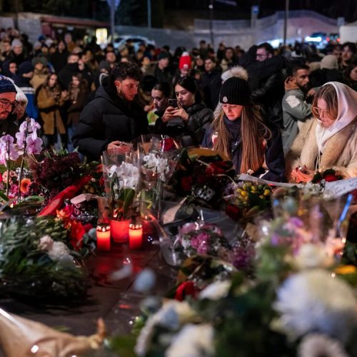 People lay flowers and light candles for the victims of the fire at the "Le Constellation" bar and lounge during New Year's celebration, in Crans-Montana, Switzerland, Thursday, Jan. 1, 2026. (Alessandro della Valle/Keystone via AP)