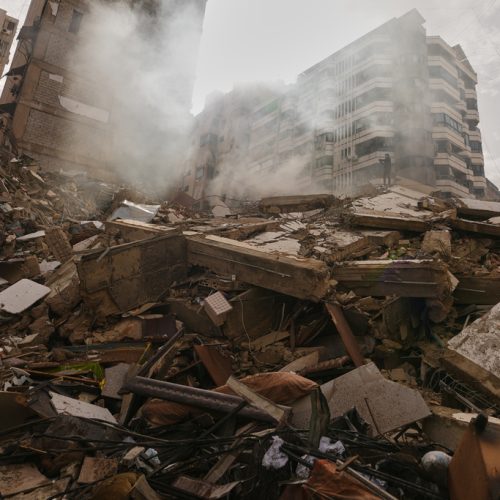 A man stands atop the rubble of a building destroyed in an Israeli airstrike as a bulldozer clears debris in Dahiyeh, Beirut's southern suburbs, Lebanon, Saturday, March 14, 2026. (AP Photo/Hassan Ammar)