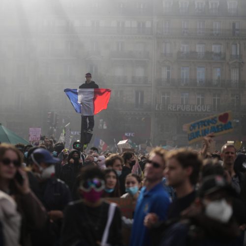 A protester holds a French flag at Republic Square during a demonstration against rising living costs, joining students' grievances, in Paris, Saturday, Oct. 17, 2026. (AP Photo/Thibault Camus)