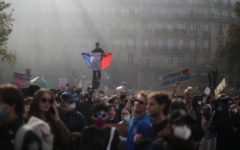 A protester holds a French flag at Republic Square during a demonstration against rising living costs, joining students' grievances, in Paris, Saturday, Oct. 17, 2026. (AP Photo/Thibault Camus)