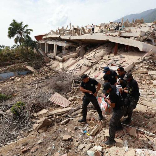 Police carry a body recovered from the rubble of a building in La Guaira, Venezuela, Thursday, June 25, 2026, a day after successive powerful earthquakes struck the country. (AP Photo/Javier Campos)