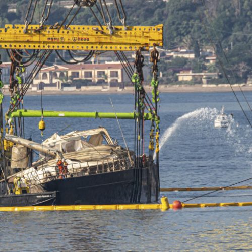 The hull of the superyacht Bayesian, which sank near Palermo, Sicily, on August 19, 2024, is lifted by cranes during salvage operations off the village of Porticello Saturday, June 21, 2025. (AP Photo/Salvatore Cavalli)