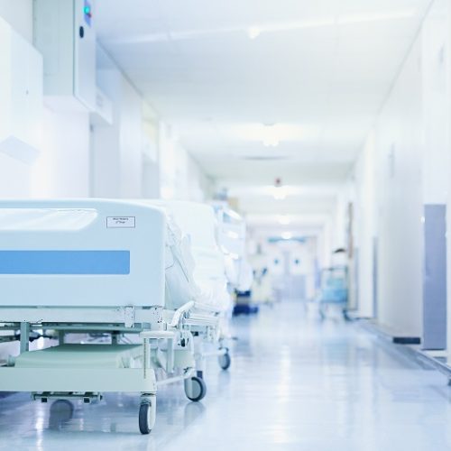 Shot of a hospital bed in an empty corridor of a modern hospital