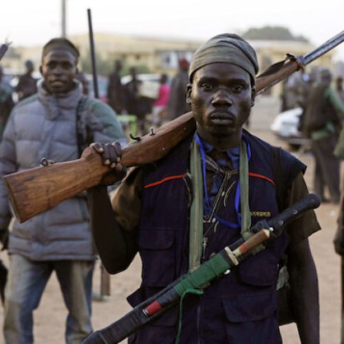 FILE- In this  Wednesday, Nov. 25, 2014 file photo, Hunters gathered during a meeting in Yolo, Nigeria. Thousands of Nigerian hunters, armed with charmed amulets and intimate knowledge of harsh terrain, are preparing an offensive against the Boko Haram extremists who have ravaged the northeast for a decade, calling it "high time” they help soldiers end the deadly insurgency. (AP Photo/Sunday Alamba, File)