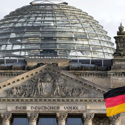 A national flag of Germany waves in front of the Reichag building, home of the German federal parliament Bundestag, in Berlin, Germany, Monday, Jan. 3, 2022. Slogan reads: 'To The German People'. (AP Photo/Michael Sohn)