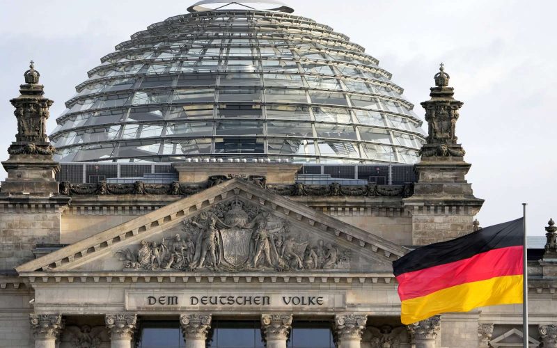 A national flag of Germany waves in front of the Reichag building, home of the German federal parliament Bundestag, in Berlin, Germany, Monday, Jan. 3, 2022. Slogan reads: 'To The German People'. (AP Photo/Michael Sohn)
