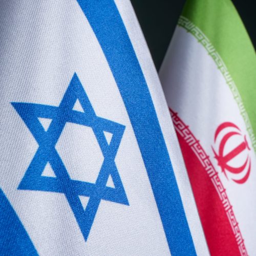 Flags of Israel and Iran, as conflict between countries.