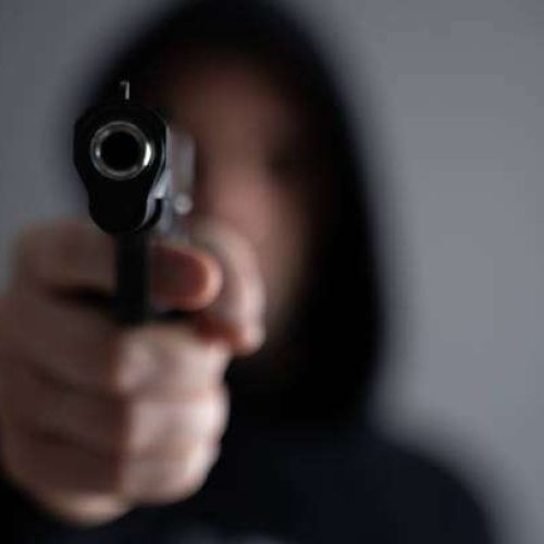 Criminal aiming gun camera, threatening burglar at victim.