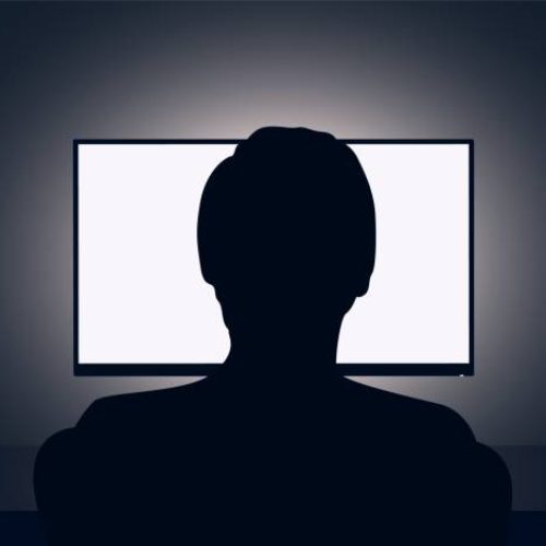 Vector illustration of man sits in front of a blank monitor in dark room