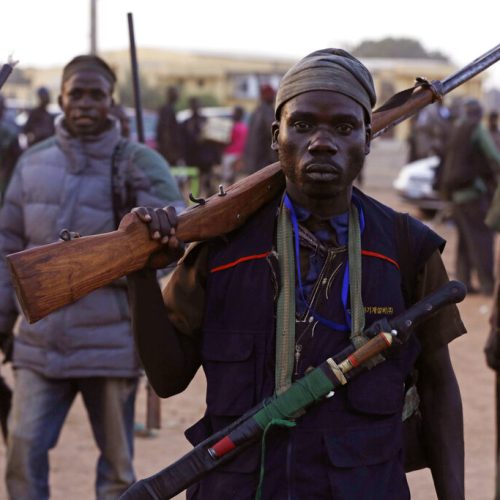 FILE-In this file photo taken on Wednesday, Nov. 25, 2014, vigilantes and local hunters armed with locally made guns gather before they go on patrol in Yola, Nigeria,  Islamic extremists are rampaging through villages in northeast Nigeria's Adamawa state, killing, burning and looting with no troops deployed to protect civilians, fleeing villagers said Wednesday, Jan. 28, 2015. (AP Photo/Sunday Alamba, File)