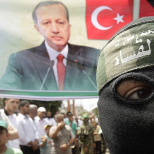 A masked member of Hamas stands in front of a banner depicting Turkey's Prime Minister Tayyip Erdogan during a protest in Central Gaza Strip June 4, 2010, against Israel's interception of Gaza-bound ships. Israeli marines stormed a  Turkish aid ship bound for Gaza on Monday and at least nine pro-Palestinian activists were killed, triggering a diplomatic crisis and an emergency session of the U.N. Security Council. REUTERS/Ibraheem Abu Mustafa (GAZA - Tags: POLITICS CIVIL UNREST) - RTR2ER4P
