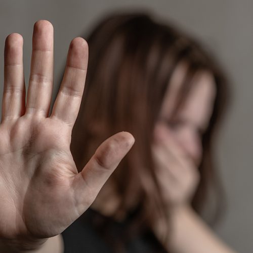 Crying teenage girl showing a stop sign with her hand