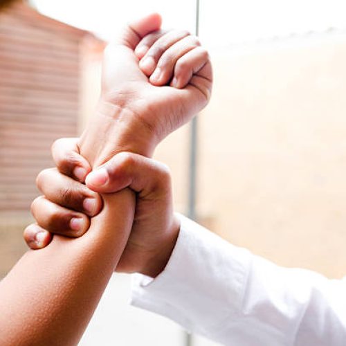 A school boy grabs a school girls arm.